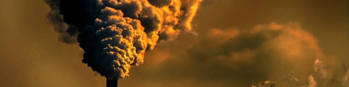 pexels-photo-929385-929385 A factory emitting smoke clouds against a dark sunset sky, illustrating air pollution and industrial impact.